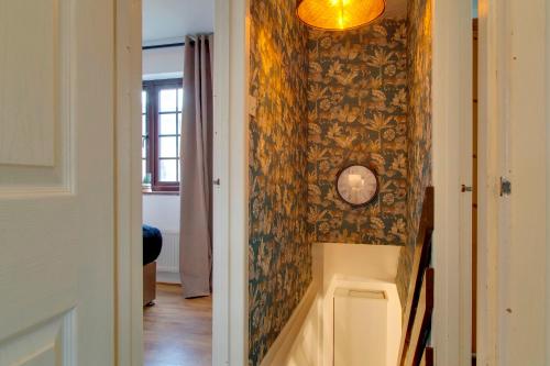 einen Flur mit einer Wand mit einer Uhr drauf in der Unterkunft Stylish Victorian Terrace in Central Cambridge Pass the Keys in Cambridge