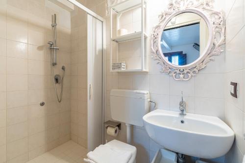 a bathroom with a sink and a toilet and a mirror at Casamari nel centro di Marzamemi in Marzamemi