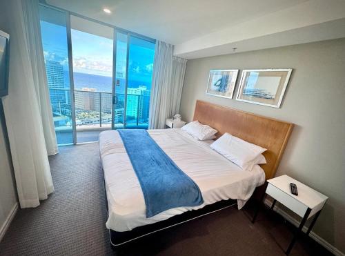 une chambre avec un grand lit avec une grande fenêtre dans l'établissement Level 15 - Hilton Surfers Paradise, à Gold Coast
