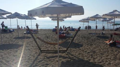 una spiaggia con persone sedute su sedie e ombrelloni di 4U Apartment a Burgas