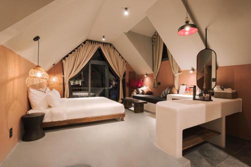 a bedroom with a bed and a living room at The Aratana Villa in Da Lat