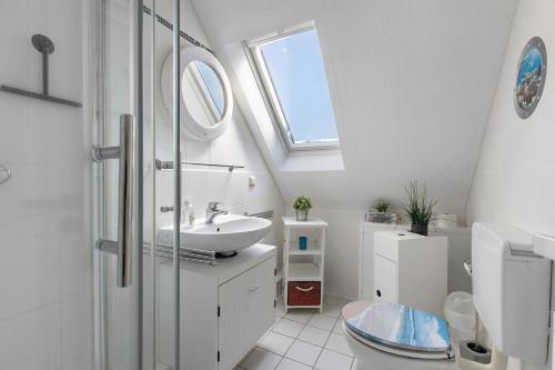 La salle de bains est pourvue d'un lavabo, de toilettes et d'une lucarne. dans l'établissement Fewo Küstkieker, à Sankt Peter-Ording