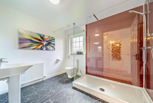 a bathroom with a shower and a sink and a toilet at La Fortuna Lodges in Stirling