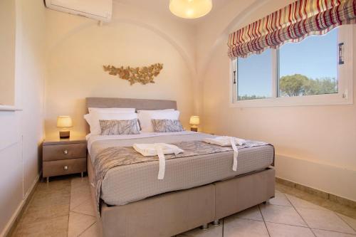 un dormitorio con una cama y una ventana en Villa Chrysoula, en Alikanas