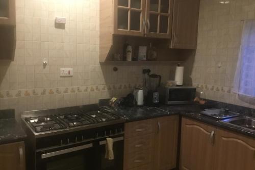 a kitchen with a stove and a counter top at 1 Bed Apartment Sleeps 2 - Parking Garden Wifi in Accra