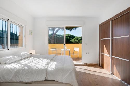Un dormitorio blanco con una cama y una ventana grande. en Villa Germany, en Poblado de Sancti Petri