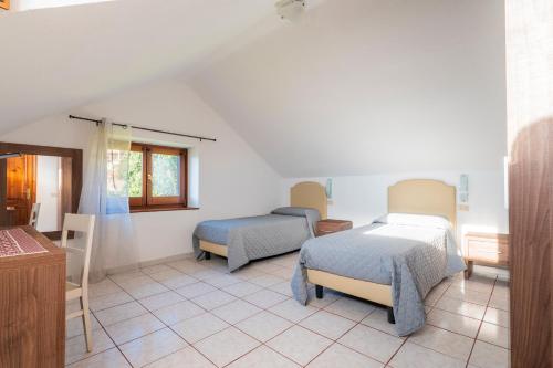 ein Schlafzimmer mit zwei Betten und einem Tisch und Stühlen in der Unterkunft Appartamento Villanova in Villanova Strisaili