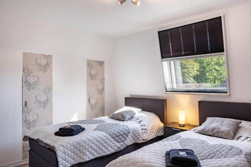 ザンデにあるFerienhaus Ihmeのベッド2台と窓のある寝室