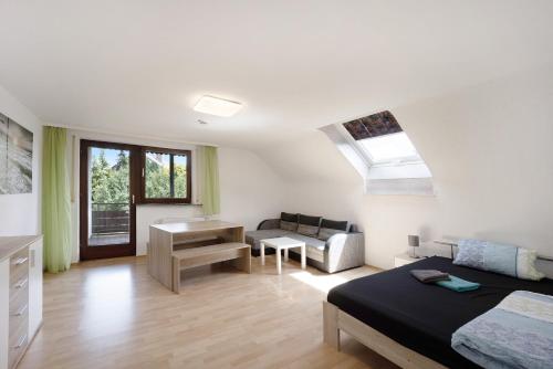 a bedroom with a bed and a living room at Ferienwohnung Sonnenbühl in Aulendorf