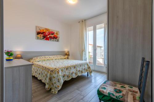 a bedroom with a bed and a table and a window at Tirreno apartment in Alghero