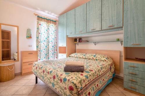 a bedroom with a bed and blue cabinets at Attico vista mare Borgo La Palma 16 in Badesi