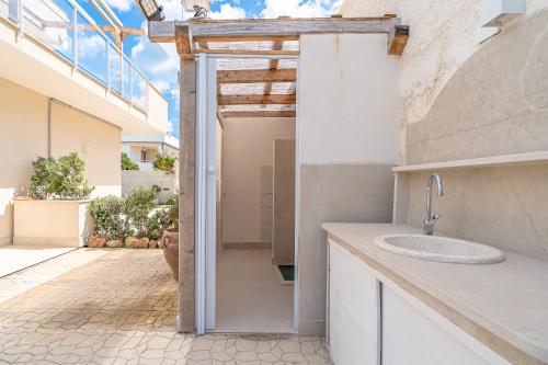 eine Küche mit einem Waschbecken und einem offenen Eingang in der Unterkunft Bove Marino Apartments Marzamemi in Reitani