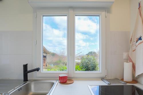 a kitchen with a sink and a window at Fusains 5 petit-déjeuner vue mer in Saint-Quay-Portrieux