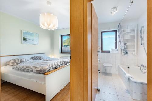 WesterholzにあるKüstenkindのベッドルーム1室(ベッド1台付)、バスルーム(バスタブ付)が備わります。