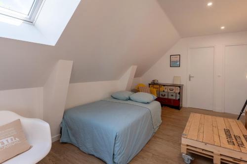 ein Schlafzimmer mit einem Bett mit blauen Kissen darauf in der Unterkunft Traou Mad in Merlevenez
