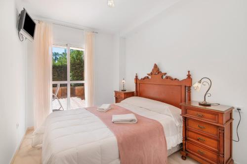 イスランティージャにあるApartamento Las Arenasのベッドとドレッサーと窓のある寝室