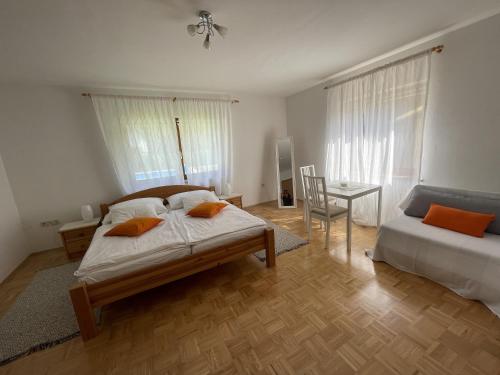 a bedroom with a bed and a table with a chair at Haus Linsendorf in Gallizien