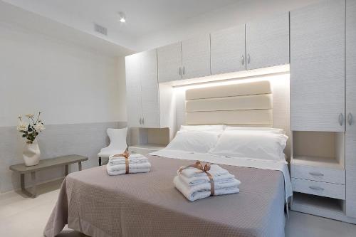 a bedroom with a bed with towels on it at Ricky's Luxury Apartment in Misano Adriatico