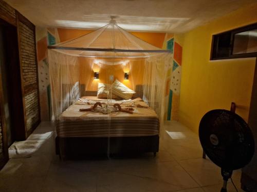 a bedroom with a bed with a canopy at Castello Malu in Parajuru