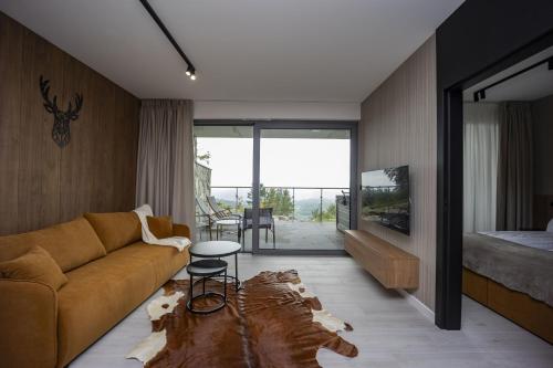 un salon avec un canapé et un lit dans l'établissement Sky Hill Apartments Szklarska Poręba, à Szklarska Poręba