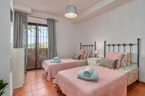 a bedroom with two beds with towels on them at Garden Apartment in Frigiliana in Frigiliana
