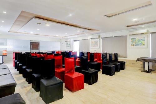 a conference room with red and black chairs at Hotel O Skyland in Ahmedabad