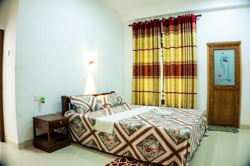 a bedroom with a bed and a table and a window at Green Edge Residences in Dambulla