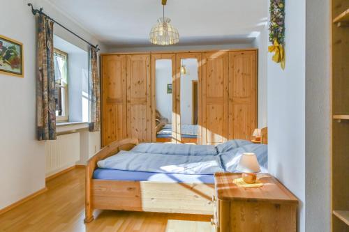 a bedroom with a bed with wooden cabinets and a table at Katharinenhof Ferienwohnung Alpspitz (4) in Garmisch-Partenkirchen