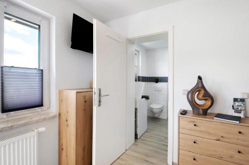 a white bathroom with a toilet and a window at Ferienwohnung Pfauenhof in Harztor