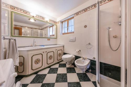 une salle de bain avec toilettes, lavabo et douche dans l'établissement Ciasa Sommavilla Calendula, à Vigo di Fassa
