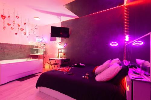 a bedroom with a bed with pink lights on it at Love Room avec Balnéo in Toulon