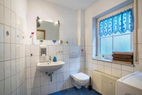 a white bathroom with a sink and a toilet at Ferienwohnung Schläfer in Kappel-Grafenhausen