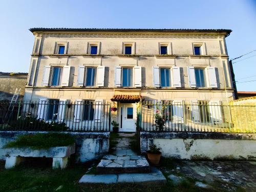 CourbillacにあるCharmant studio le 1864の青い窓と白いドアのある大きな建物