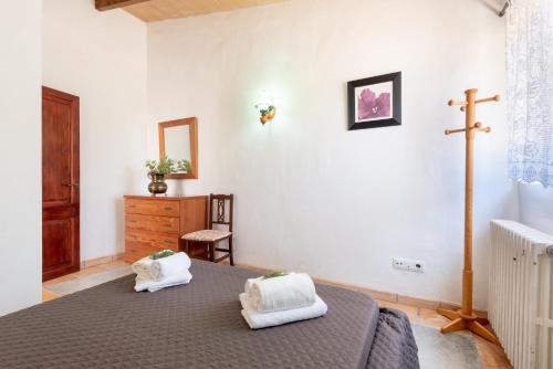 a bedroom with a bed and a cross on the wall at Ses Eres in Artá