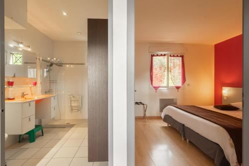 un dormitorio con una cama y un baño en Royan, en Saint-Simon-de-Bordes