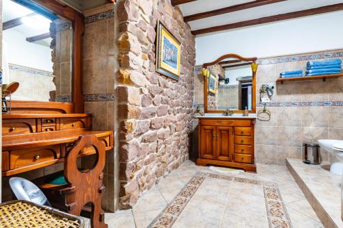 a bathroom with a sink and a stone wall at Casa Retiro Vilafames in Vilafames