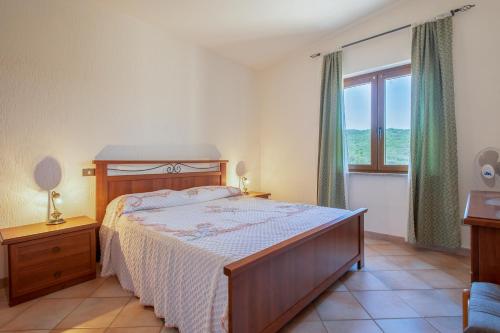 a bedroom with a bed and a large window at Casa Valeria Costa Paradiso in Li Valcaggi