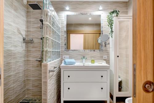 ein Badezimmer mit einem weißen Waschbecken und einem Spiegel in der Unterkunft Casa Jardín in Playa Blanca