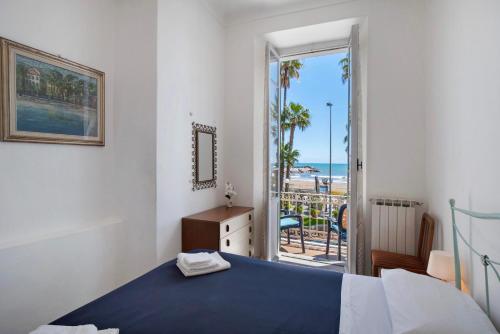 a bedroom with a bed and a view of the beach at Casa Edda - Sea view in Diano Marina