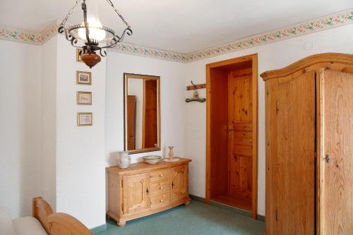 a room with a mirror and a wooden dresser at Gästehaus Marianne - Ferienwohnung in Farchant