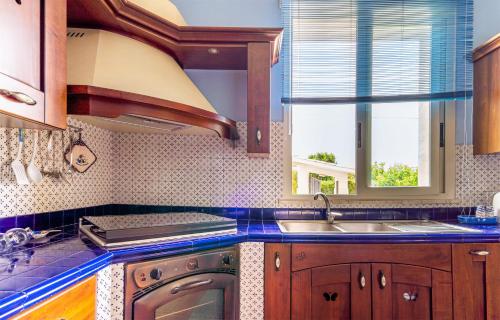 a kitchen with a sink and a stove at Villa Raffa in Avola