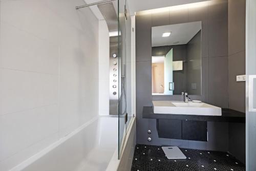 ルース・デ・タビラにあるAlecrim Lux Tavira Residence 4Mの洗面台と鏡のあるバスルーム