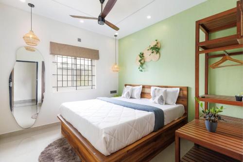 a bedroom with a bed and a shower and a mirror at The Garden Retreat by StayJadePool2BHKLawn in Berikai