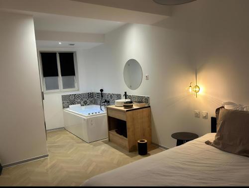 ein Badezimmer mit einem Bett, einem Waschbecken und einer Badewanne in der Unterkunft SPA & Détente - Cocon romantique au coeur de Moulins in Moulins