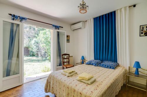 Un dormitorio con una cama y una ventana grande. en Domaine du Courroussouve, en Oppède
