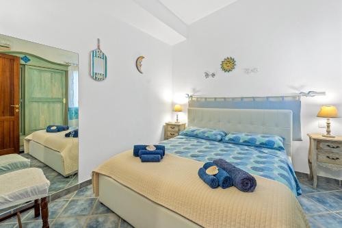 een slaapkamer met een bed met blauwe handdoeken erop bij Villa Vittoria in Villasimius