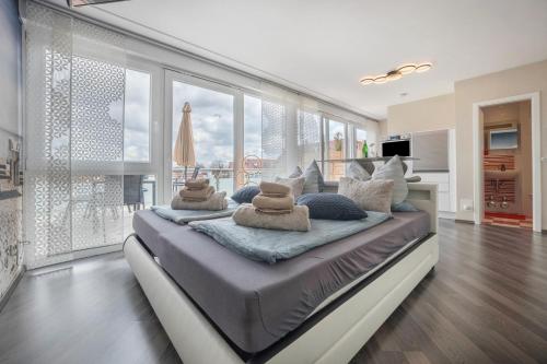a large bed in a room with large windows at Studio in Steinhude