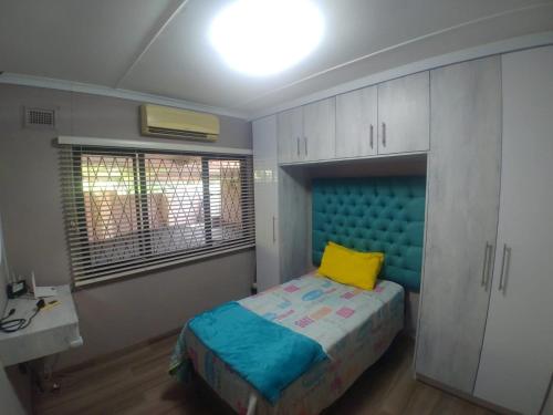 a bedroom with a bed with a yellow pillow on it at 220 Mclarty in Durban