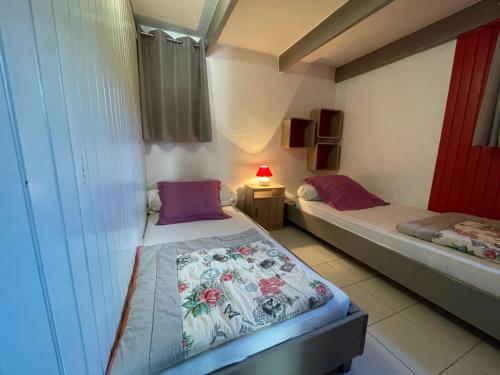 une petite chambre avec deux lits et une lampe dans l'établissement Gîte Grange - Village De Gîtes, à Rosières