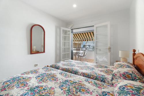 a bedroom with a bed and a couch and a mirror at Apto Tomasol in Los Cristianos